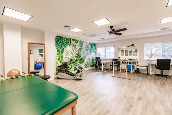 Brightly lit therapy room with exercise equipment