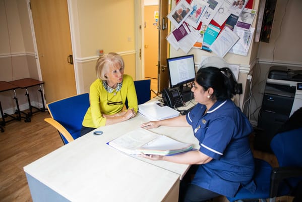 Staff member discussing with a resident in an office setting