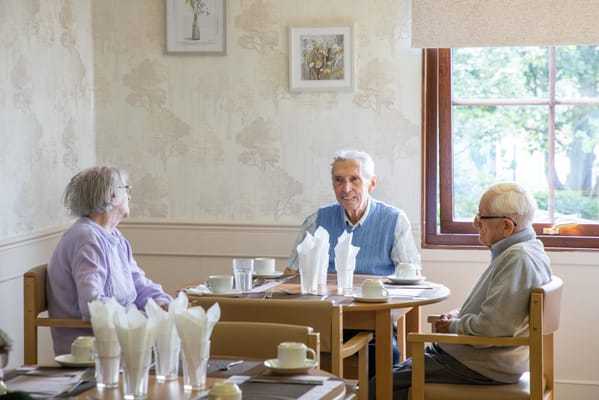 Residents enjoying conversation in a dining room