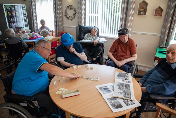 Residents engaged in a game around a table