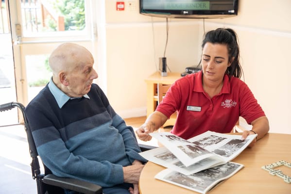 Staff assisting a resident with photo album