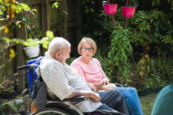 Two residents enjoying conversation in a garden