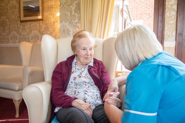 A caregiver talking with an elderly resident in a cozy interior