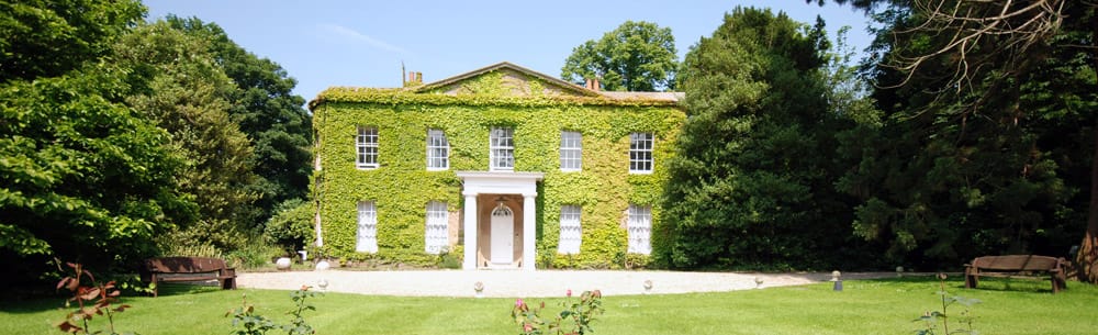 Exterior view of Upton House covered in greenery