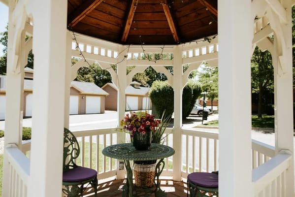 Gazebo with flowers and seating in a garden