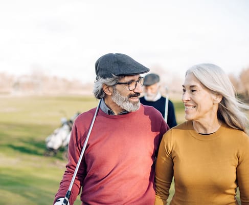 A joyful couple walking on a golf course