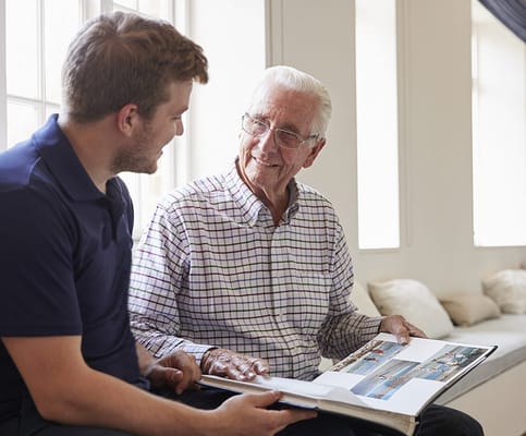 A staff member and resident looking at a photo album