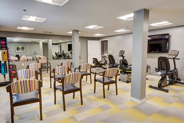 A fitness room with exercise equipment and seating