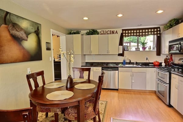 Modern kitchen area with a dining table and appliances