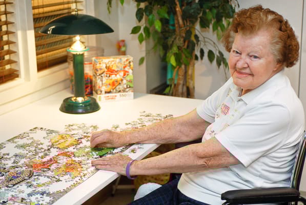 Resident working on a jigsaw puzzle in the activity room