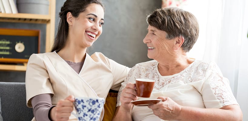 Caregiver and resident sharing a moment with tea