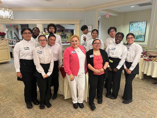 Staff members posing in the dining area with food