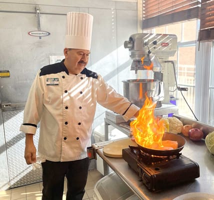 Chef preparing flaming dish in the kitchen