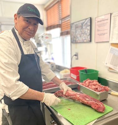 Chef preparing meat in a kitchen environment