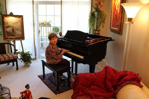 Resident playing piano in a comfortable living room