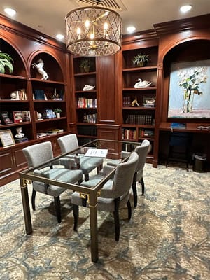 Cozy common area with a glass table and bookshelves