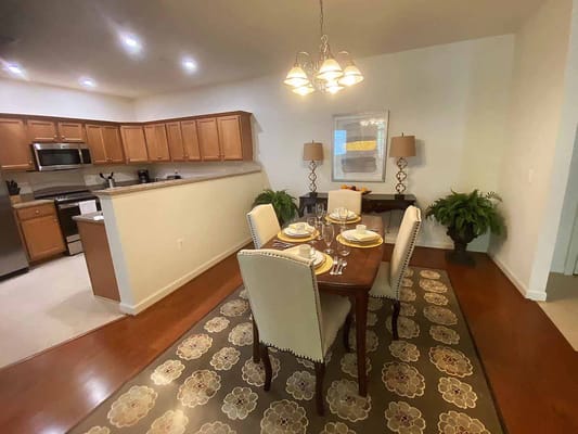Dining area with table settings and kitchen in view
