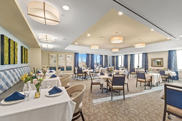 Dining room with elegantly set tables and flowers