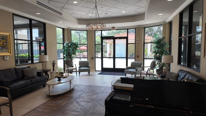 Cozy lobby area with seating and piano at Excellence Senior Living.
