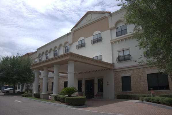 Entrance view of Excellence Senior Living facility with columns and landscaping