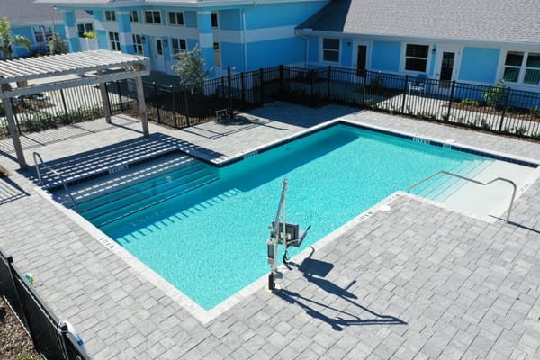 Aerial view of the swimming pool surrounded by a modern patio at Hampton Manor.