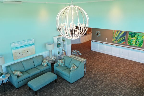 Cozy lobby area with blue sofas and a large chandelier.