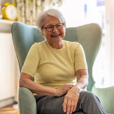 Resident smiling in a cozy chair