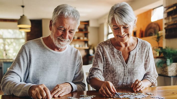 Two senior residents enjoying puzzle activity indoors