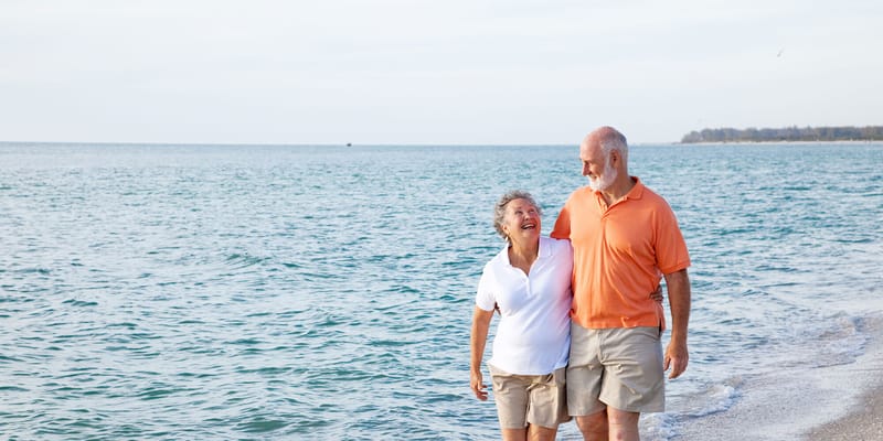 Couple walking along the beach by the water