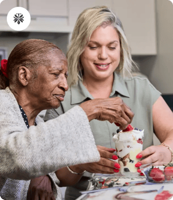 Resident and staff member enjoying dessert activity together