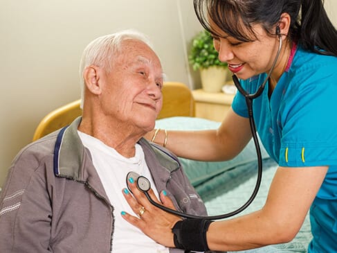 A caregiver with a resident in a bright interior room