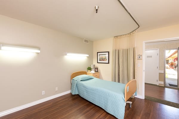 Private resident room with bed and bedside table