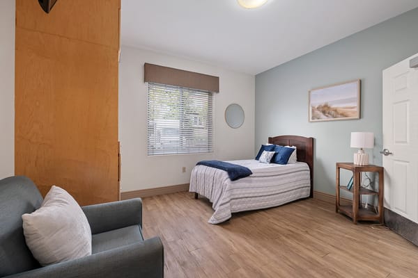 Bright and cozy resident room with a bed and seating area