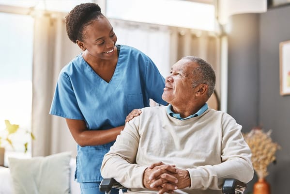 Caregiver smiling at a resident in a cozy room