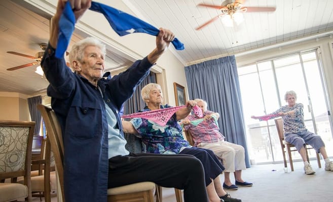 Seniors participating in a group exercise activity indoors