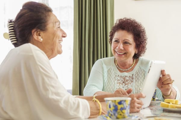 Two residents smiling and interacting at a table