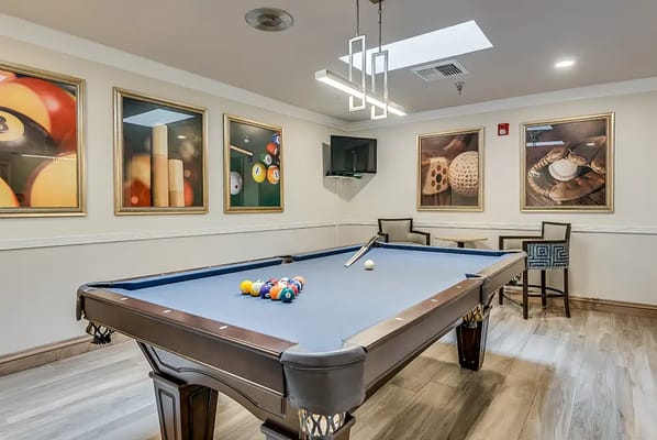 Activity room with a pool table and framed art