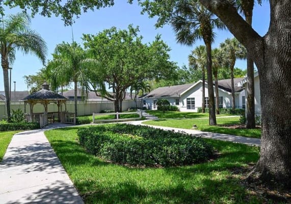 Walking path through landscaped outdoor space with palm trees