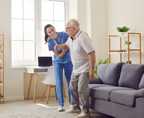 Caregiver assisting an elderly gentleman in a bright room