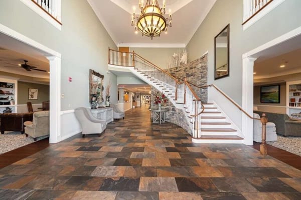 Brightly lit lobby with elegant staircase and decor