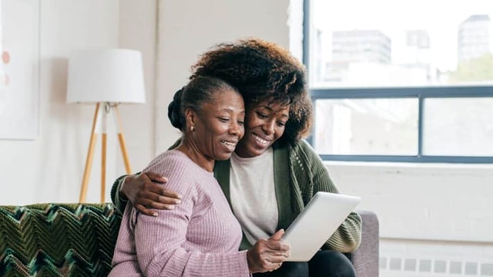 Two women sharing a moment with a tablet indoors
