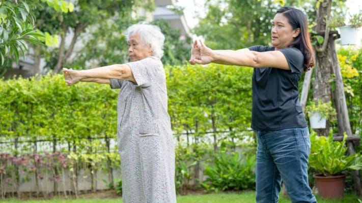 Residents and staff participating in an outdoor exercise activity