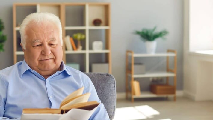 Senior man reading a book in a cozy living area