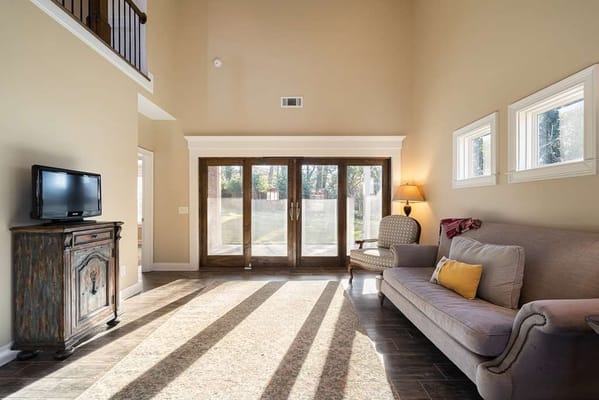 Bright common area with a sofa and large windows