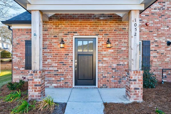 Front entrance of a brick building with porch lights