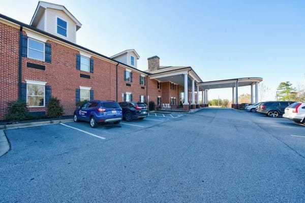 Front view of a senior living facility with parking lot