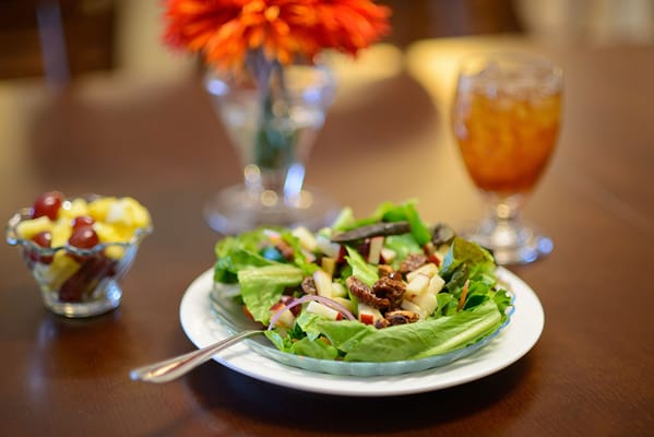 A fresh salad and fruit dessert on a dining table