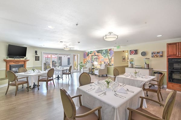 Brightly decorated dining room with tables set for meals.