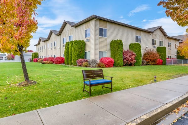 A view of the exterior of Ellensburg Senior Living with landscaped gardens