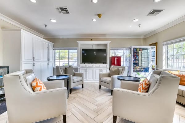 Common area with seating and TV in a senior living facility